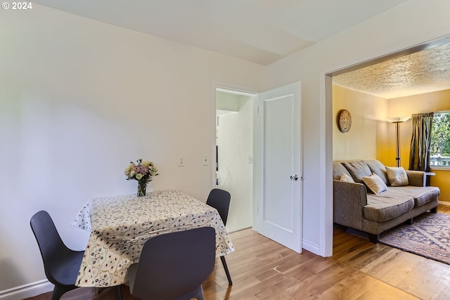 dining room with a textured ceiling and hardwood / wood-style flooring