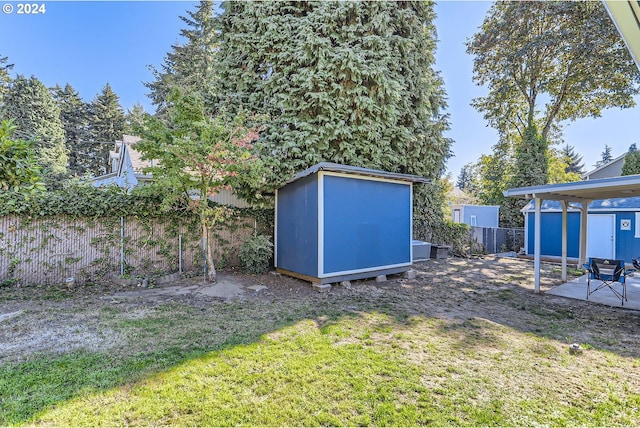 view of yard featuring a storage shed and a patio