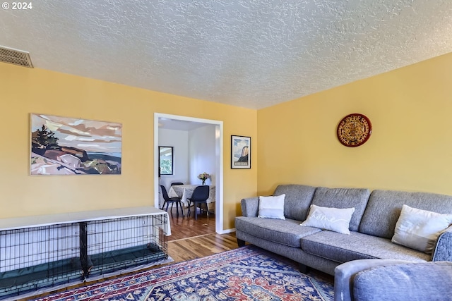 living room with wood-type flooring and a textured ceiling