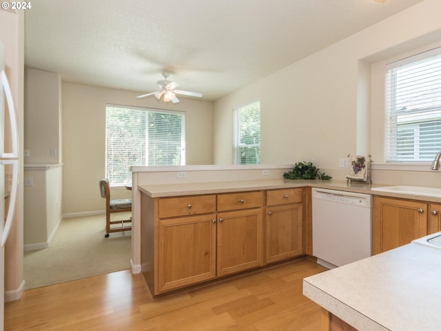 kitchen with light wood-type flooring, ceiling fan, white dishwasher, and kitchen peninsula