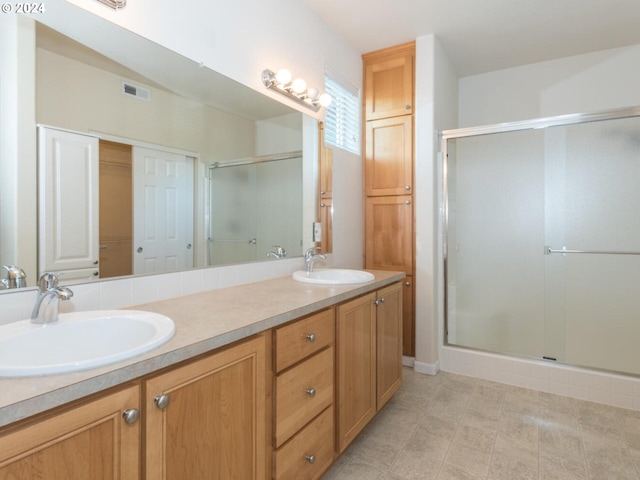 bathroom with tile floors, dual sinks, an enclosed shower, and oversized vanity