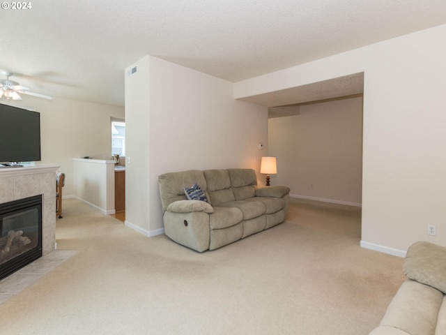 carpeted living room featuring ceiling fan and a fireplace