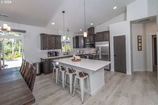 kitchen featuring visible vents, a kitchen island, appliances with stainless steel finishes, light countertops, and pendant lighting