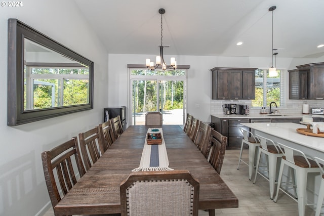 dining space with lofted ceiling, wood finished floors, a notable chandelier, and recessed lighting