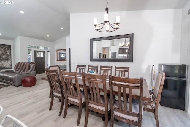 dining space featuring a chandelier, lofted ceiling, light wood finished floors, and recessed lighting