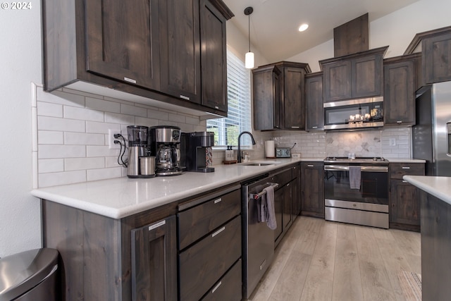 kitchen featuring appliances with stainless steel finishes, light countertops, and a sink