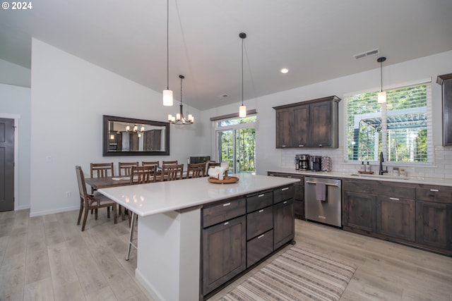 kitchen with a sink, visible vents, light countertops, stainless steel dishwasher, and a center island