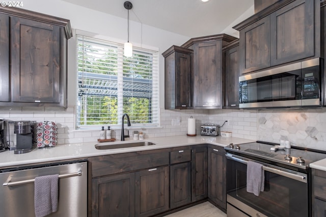 kitchen featuring backsplash, appliances with stainless steel finishes, light countertops, and a sink