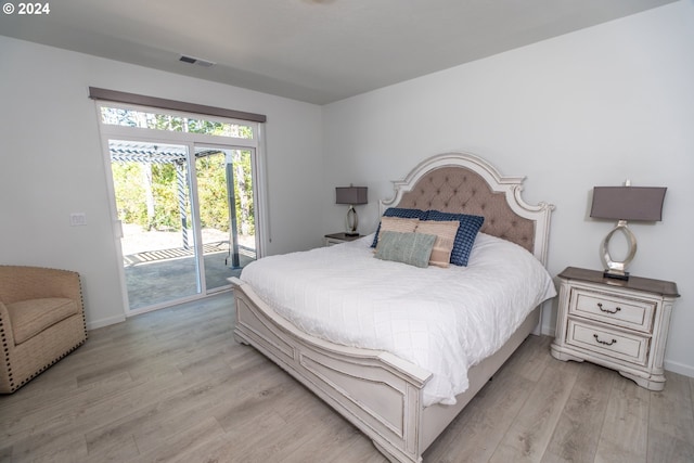 bedroom with baseboards, light wood-type flooring, visible vents, and access to exterior