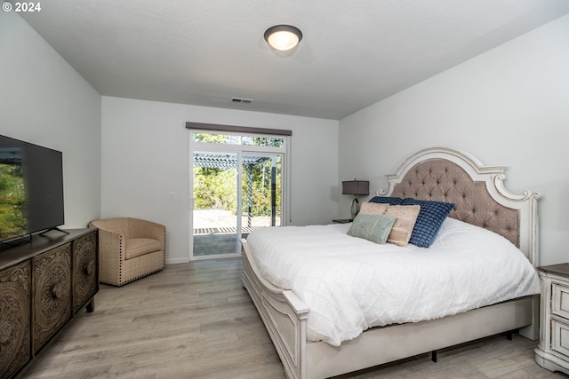 bedroom featuring access to exterior, visible vents, and light wood finished floors