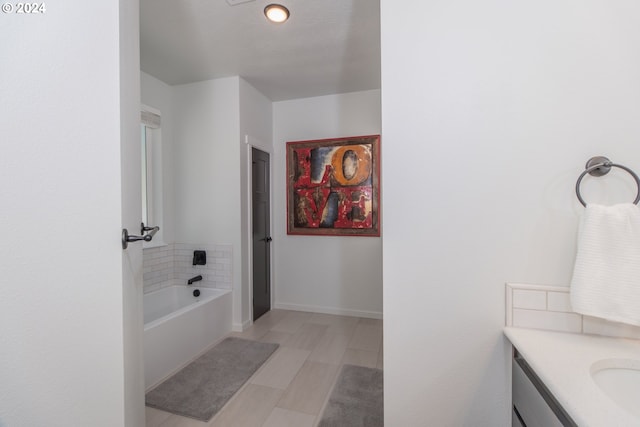 bathroom featuring a garden tub, vanity, and baseboards