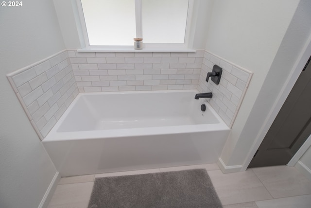 bathroom featuring tile patterned flooring and a bath