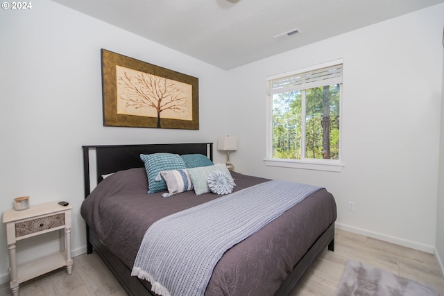 bedroom with light wood-style floors, baseboards, and visible vents