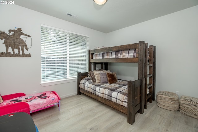 bedroom featuring baseboards, visible vents, and light wood-style floors