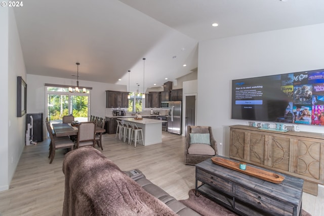 living area featuring light wood-style floors, recessed lighting, high vaulted ceiling, and an inviting chandelier