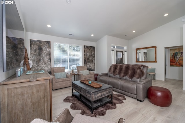 living room featuring lofted ceiling, light wood finished floors, visible vents, and recessed lighting