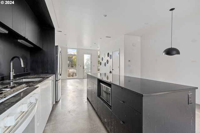 kitchen featuring appliances with stainless steel finishes, a spacious island, decorative light fixtures, and sink