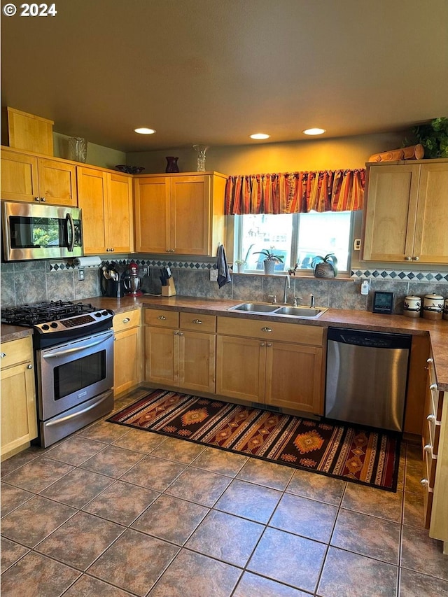 kitchen featuring stainless steel appliances, dark tile patterned flooring, tasteful backsplash, and sink