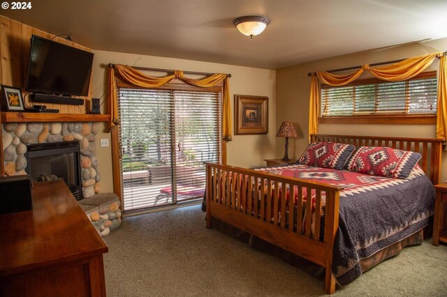 bedroom with access to outside, a fireplace, and carpet flooring