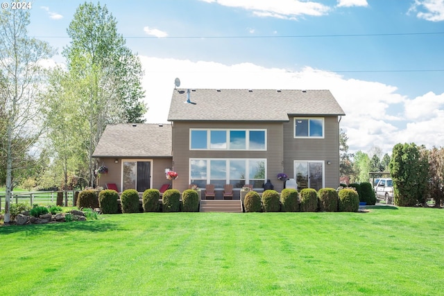 rear view of house featuring a lawn