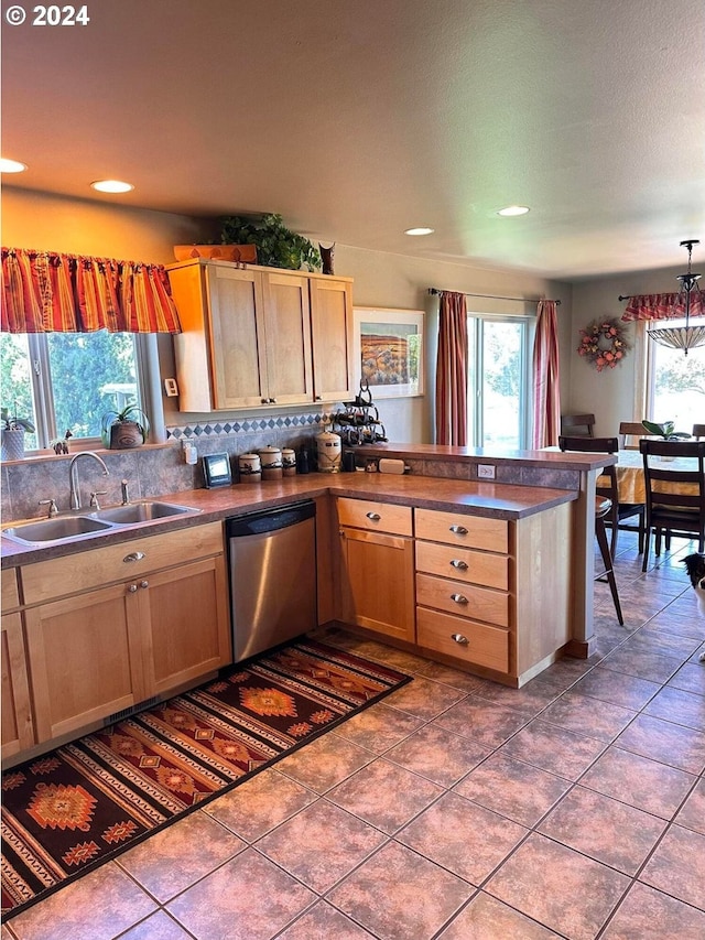 kitchen with tasteful backsplash, plenty of natural light, stainless steel dishwasher, and sink