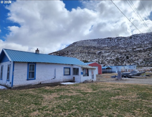 rear view of house with a lawn and a mountain view