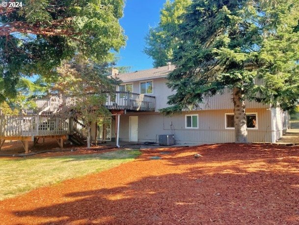 back of house featuring a wooden deck and central air condition unit