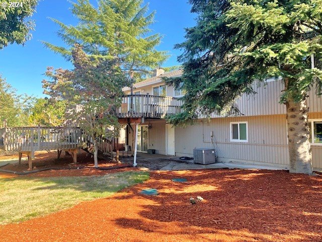 back of house with cooling unit, a patio area, and a deck