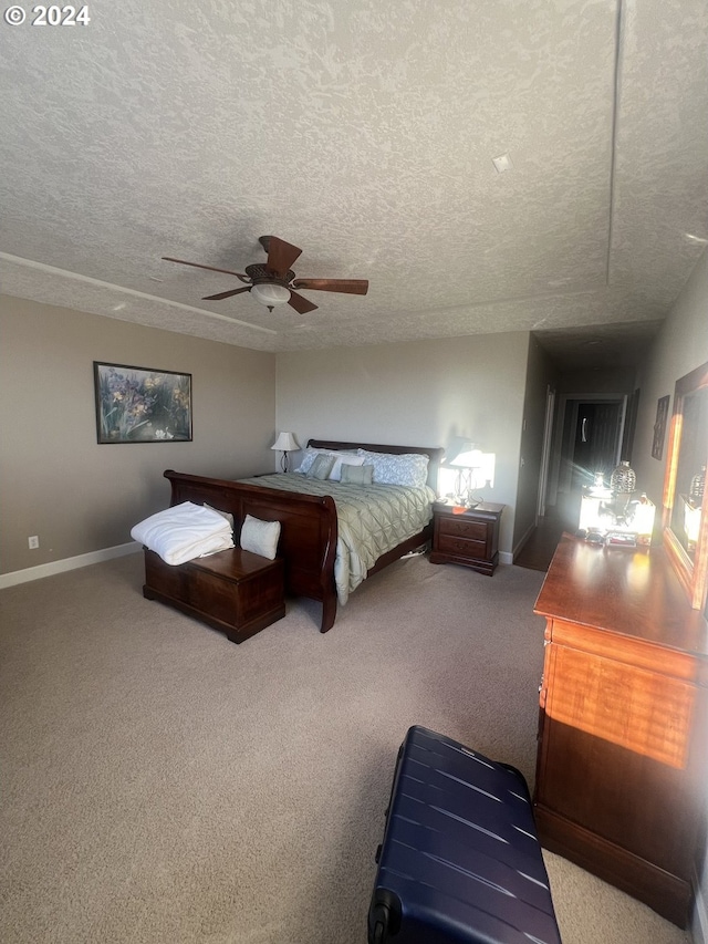 carpeted bedroom featuring ceiling fan and a textured ceiling