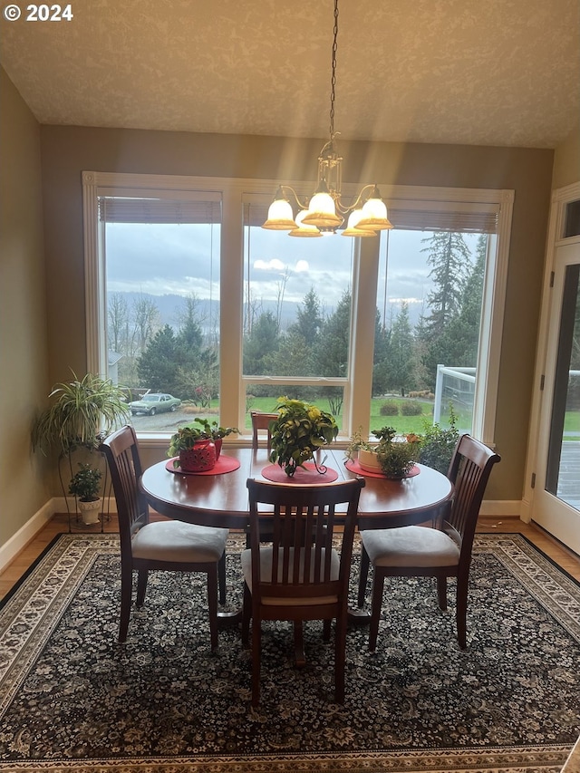 dining area with a textured ceiling, an inviting chandelier, and a wealth of natural light