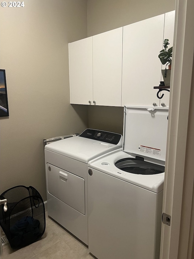 washroom with separate washer and dryer and cabinets