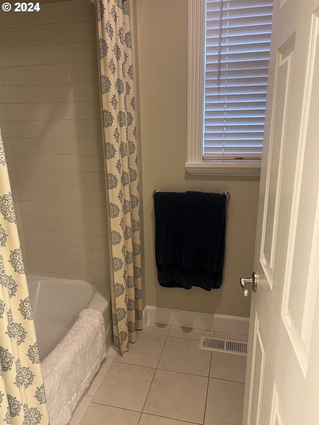 bathroom with tile patterned floors and shower / bath combo with shower curtain