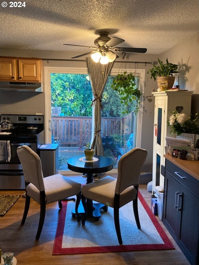 dining space with hardwood / wood-style flooring, ceiling fan, and a textured ceiling