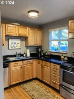 14655 SW 76th Ave Unit 5, Tigard, OR 97224 - kitchen with stainless steel appliances, light wood-style floors, dark countertops, light brown cabinets, and range hood
