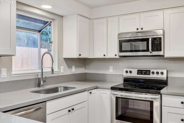 kitchen featuring white cabinets, stainless steel appliances, and sink