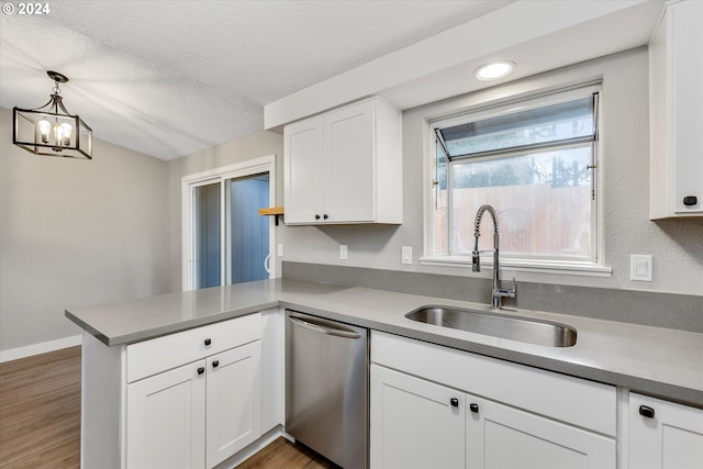 kitchen with dishwasher, sink, hanging light fixtures, kitchen peninsula, and white cabinets