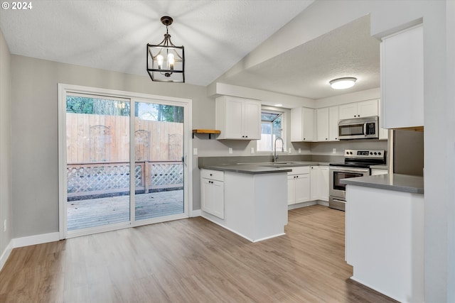 kitchen featuring sink, stainless steel appliances, light hardwood / wood-style flooring, decorative light fixtures, and white cabinets