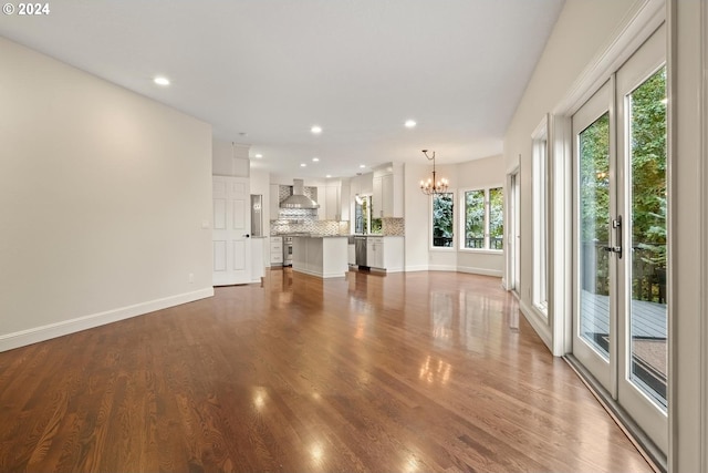 unfurnished living room with dark wood-type flooring and a chandelier