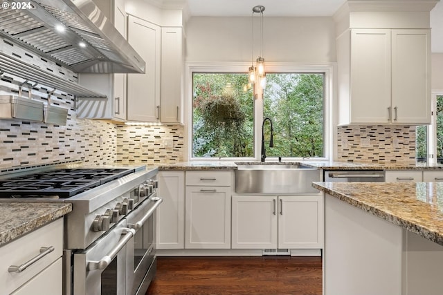 kitchen with white cabinetry, stainless steel appliances, wall chimney range hood, and sink