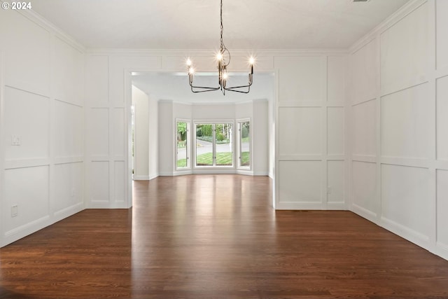 unfurnished dining area featuring crown molding, dark hardwood / wood-style flooring, and a chandelier