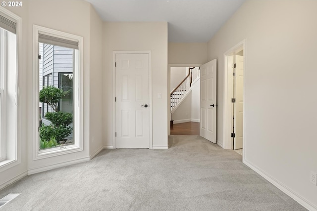 interior space featuring light carpet and multiple windows