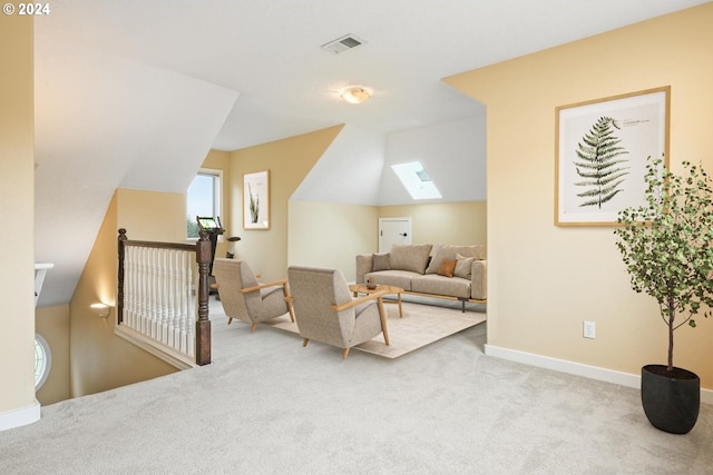 living room with lofted ceiling with skylight and light colored carpet