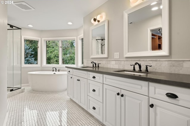 bathroom featuring vanity, shower with separate bathtub, and backsplash