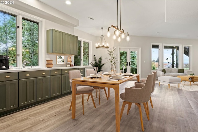 dining area featuring an inviting chandelier, sink, light hardwood / wood-style floors, and plenty of natural light