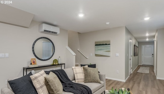 living room featuring light wood finished floors, recessed lighting, an AC wall unit, and baseboards