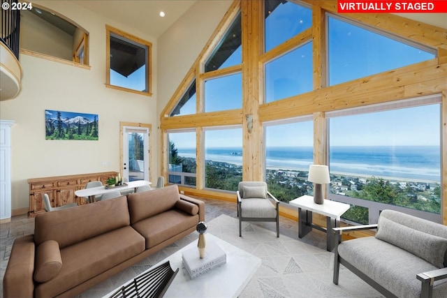 living room with a water view and high vaulted ceiling