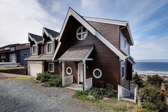 view of front of house with a view of the beach, a water view, and a garage