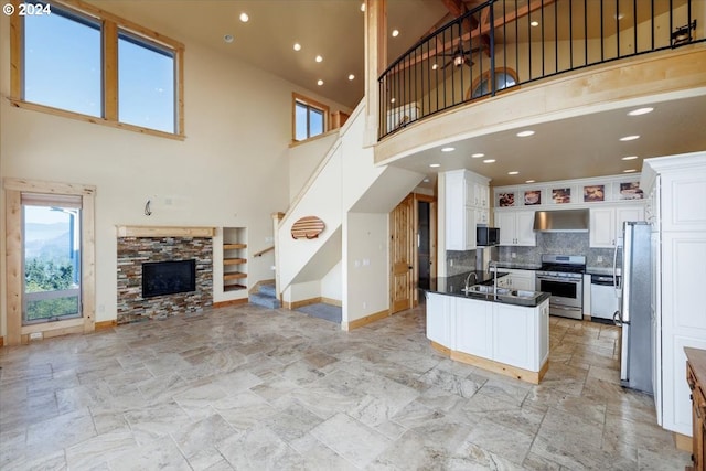 kitchen featuring stainless steel appliances, a high ceiling, and white cabinetry