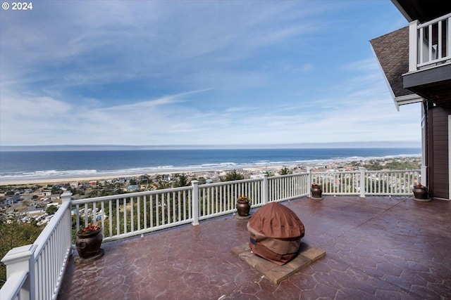 view of patio / terrace featuring a view of the beach, a water view, and a balcony