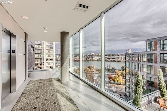 interior space with a water view and elevator